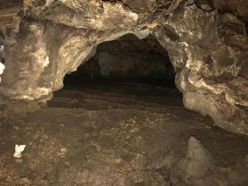 From Tirana: Hiking to Pellumbas Cave & visiting the Canyon - Entering Pellumbas, also called the Black Cave: helmet lights and a prehistoric setting